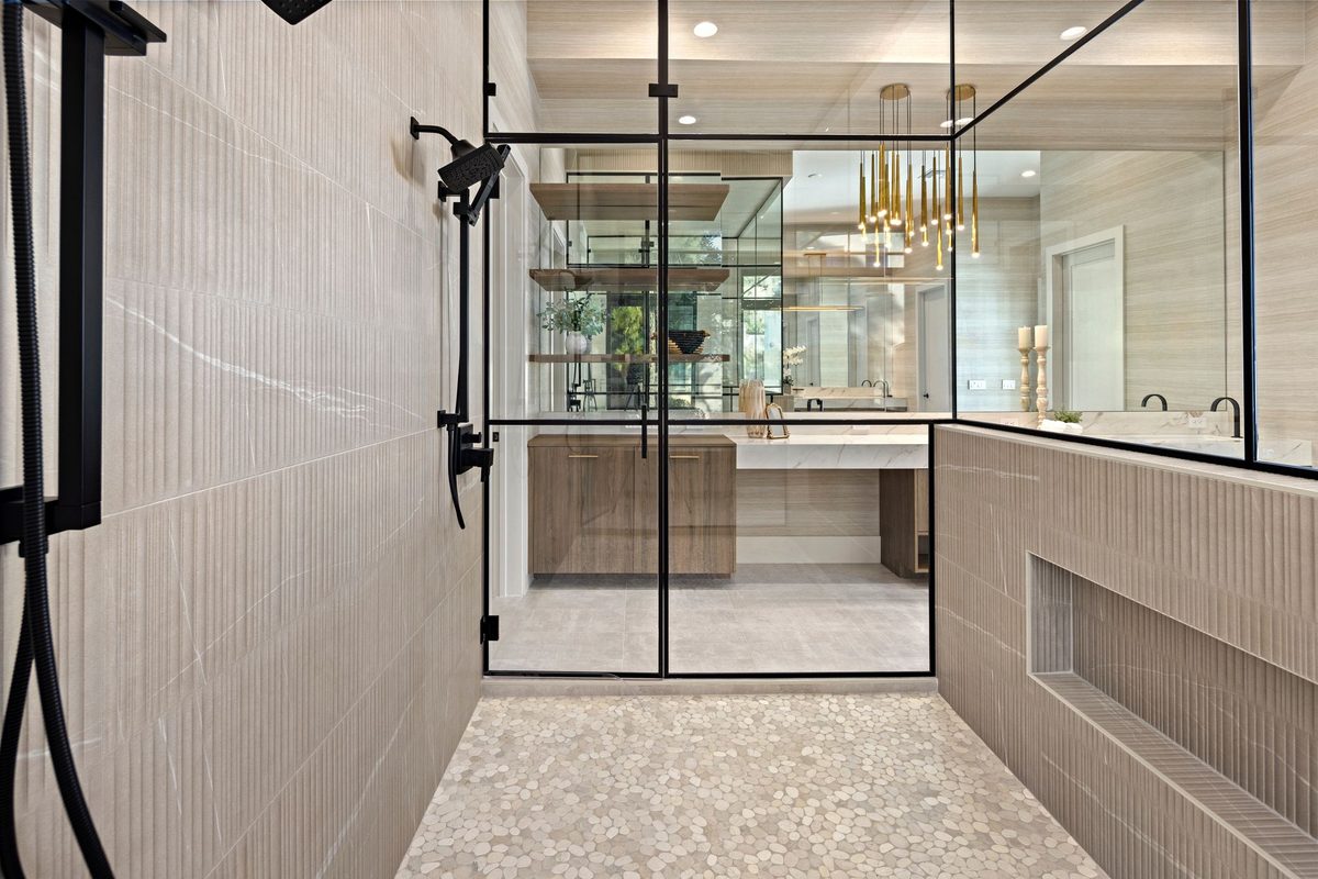 Walk-in shower with fluted porcelain walls and pebble-stone floor